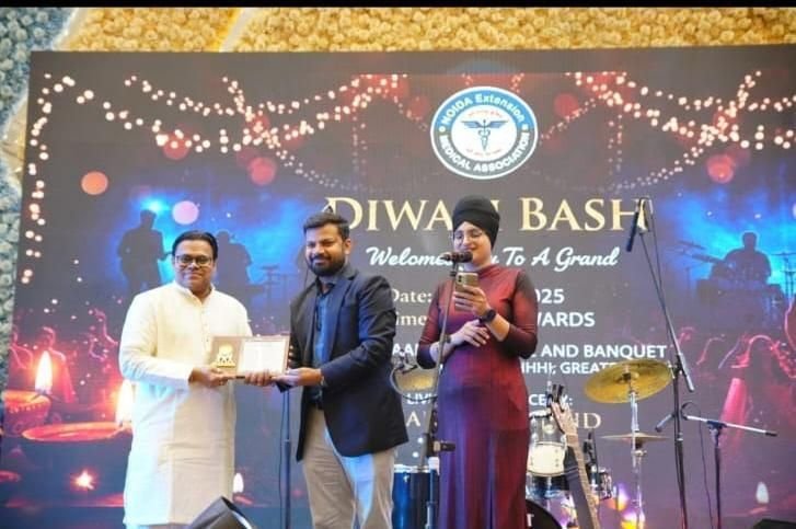 Dr. Vishal Gupta receiving a memento on stage at the Noida Extension Medical Association event